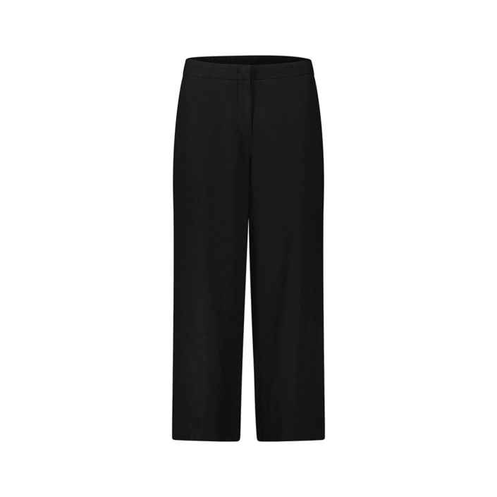 Eine schwarze Hose hängt unbewegt vor einem weißen Hintergrund, der sie betont. Keine weiteren Gegenstände oder Details sind sichtbar.
