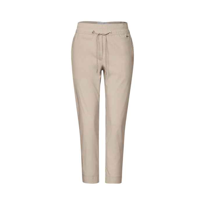 Beige Hose hängt ruhig vor einem weißen Hintergrund, mit Kordelzug an der Taille und schmalem Schnitt, geeignet für Freizeit- oder Sportbekleidung.
